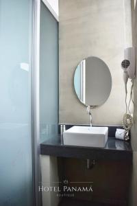 瓜亚基尔HOTEL BOUTIQUE PANAMÁ的浴室设有水槽和镜子,位于柜台上