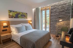 圣维森特Quinta Vale Vitis的一间卧室设有一张床和石墙