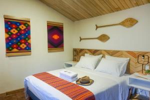 ArchidonaPacha Eco Lodge Glamping & Hotel的一间卧室,配有一张床,上面有帽子