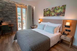 圣维森特Quinta Vale Vitis的一间卧室设有一张带石墙的大床