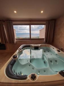 伊西翁Mani Luxury Suites and Studios in Gytheio with Private Pools的一个带窗户的客房内的按摩浴缸