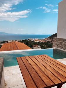 伊西翁Mani Luxury Suites and Studios in Gytheio with Private Pools的海景阳台上的木桌