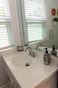 恩格尔伍德Cozy Private bedrooms Kitchen Wifi的带2扇窗户的浴室内的白色水槽