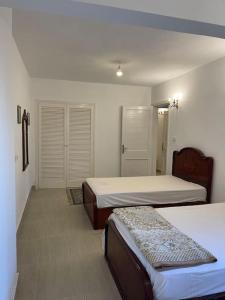 Dawwār Abū MaḩrūsCheerful fully furnished 3 bedroom villa in North Coast的一间设有两张床和两个壁橱的房间