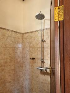 金塔马尼巴鲁娜别墅酒店的浴室里设有玻璃门淋浴