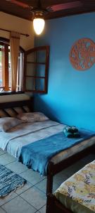 阿布拉奥Pousada Exuberante的一间卧室设有两张床和蓝色的墙壁