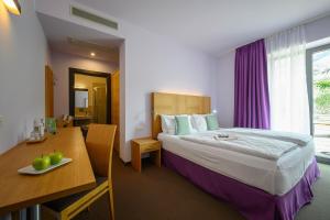 加尔达湖滨活动&家庭吉奥宜萨酒店的配有一张床、一张桌子和一张桌子的酒店客房