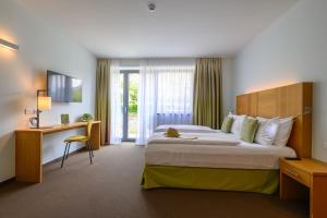 加尔达湖滨活动&家庭吉奥宜萨酒店的酒店客房设有一张大床和一张书桌。