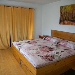 科尔尼鲁格Guest House Ema的一间卧室配有一张带粉红色鲜花的木床。