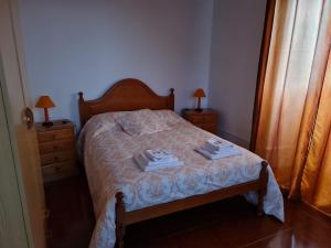 圣克鲁什达什弗洛里什Casa da Cruz的一间卧室配有一张床,上面有两条毛巾