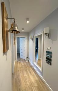 斯蒂格纳Apartment Premium Wood Baltic Park - 58m2, 3 pokoje的客房设有带木地板和灯具的走廊。