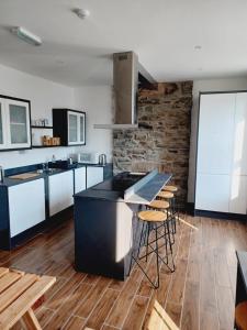 道格拉斯Voyage Hostel - Rooms with Shared Kitchen的铺有木地板的黑色岛屿厨房