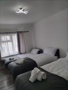 达格纳姆Remaj Service Accommodation, Sleep 7的一间带三张床和吊扇的卧室