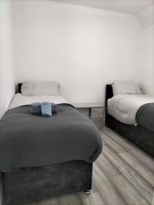 达格纳姆Remaj Service Accommodation, Sleep 7的一间卧室设有两张单人床,铺有木地板。