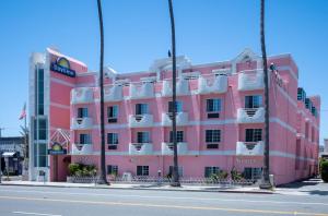 洛杉矶Days Inn by Wyndham Santa Monica的街道边的粉红色建筑