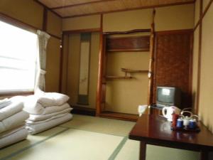 京都达亚旅馆的客房设有一张双层床和一张带电视的桌子。