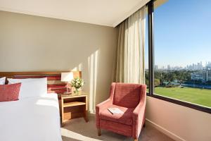墨尔本View Melbourne的卧室配有床、椅子和窗户。