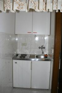 泰斯Apartments by the sea Omis - 771的厨房配有白色橱柜和水槽