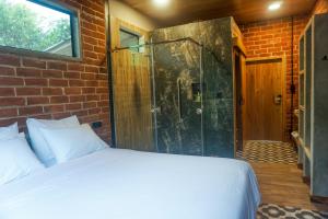 ArchidonaPacha Eco Lodge Glamping & Hotel的一间卧室设有一张床和一个玻璃淋浴间
