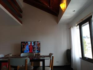 圣卡洛斯-德巴里洛切LA CASITA DE ALEX的一间设有桌子和墙上电视的用餐室
