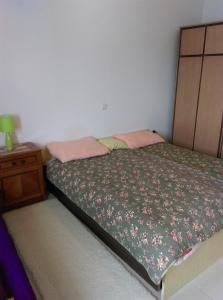 泽德瑞拉克Apartments by the sea Zdrelac, Pasman - 689的一间卧室配有一张床和一个带床罩的床头柜。