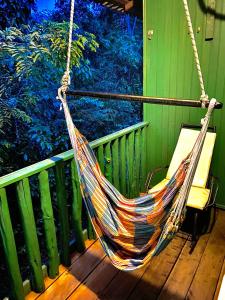 IrandubaAmazonia Jungle Hotel的挂在门廊上的吊床,带绿色围栏