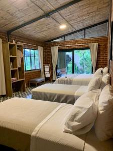 ArchidonaPacha Eco Lodge Glamping & Hotel的带窗户的客房内设有四张床。