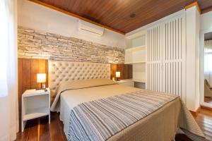 卡内拉苏珊娜维拉公园酒店的一间卧室设有一张床和砖墙