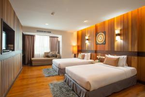 清迈Khum Phucome Hotel -SHA Extra Plus的酒店客房,设有两张床和一张沙发