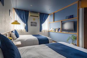 TobeHotel Teiregikan的酒店客房设有两张床和一台平面电视。