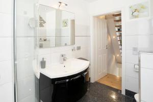 特拉弗明德Haus Traavmünn的白色的浴室设有水槽和镜子