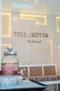 瑞诗凯诗Terrakotta Rishikesh的餐桌上装有玻璃罐的餐厅标志