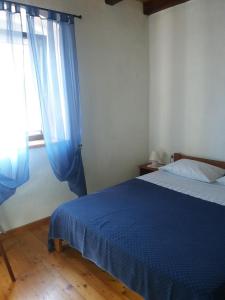 奥利布岛Holiday house with a parking space Olib - 18805的一间卧室设有蓝色的床和窗户。