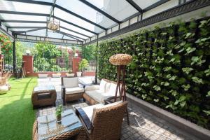 瑞诗凯诗Terrakotta Rishikesh的庭院设有绿墙、椅子和沙发
