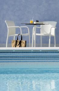 代森扎诺-德尔加达公园酒店的游泳池旁的桌椅