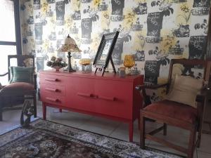 韦尔科姆Goedehoop的一间设有镜子和两把椅子的客房内的红色梳妆台