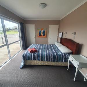 陶波The Retreat Taupo的一间卧室配有一张床、一张桌子和一个窗户。