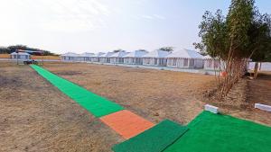 DhordoKutch Classic Resort Camp的绿橙线,在田野上,有帐篷