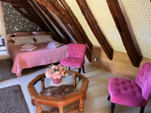 Saint-Alvèreroquebrune的一间卧室配有一张床、两把椅子和一张桌子