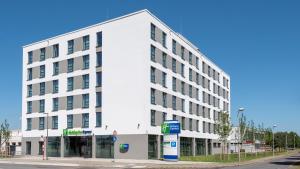 克雷费尔德Holiday Inn Express - Krefeld - Dusseldorf, an IHG Hotel的街道拐角处的白色建筑