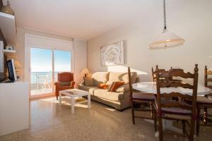 卡内·德·玛尔Maresme Beach Apartment的客厅配有沙发和桌子