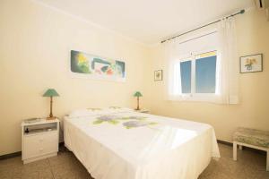 卡内·德·玛尔Maresme Beach Apartment的卧室配有白色的床和窗户。