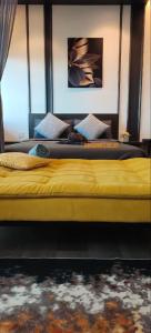 班吉SARI Homestay Vista Bangi with Wi-fi and Netflix的卧室设有两张床,配有黄色的床头板