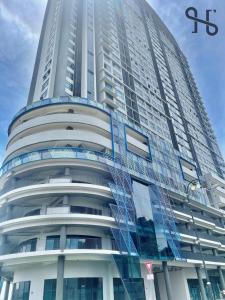 哥打京那巴鲁Homesuite' Home at Jesselton Quay的一座高大的建筑,旁边有一个标志