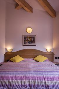 维哥迪法萨索恩索尔酒店的卧室配有一张大床,墙上有两盏灯