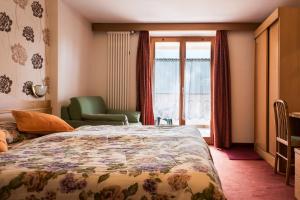 维哥迪法萨索恩索尔酒店的卧室配有床、椅子和窗户。