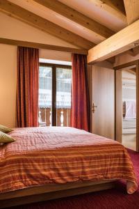 维哥迪法萨索恩索尔酒店的一间卧室设有一张大床和一个大窗户