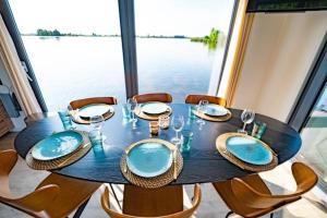 加赫Surla houseboat "Aqua Zen" Kagerplassen with tender的餐桌、椅子和一张带蓝盘的桌子