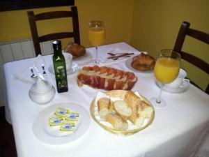 Camango卡萨代阿尔迪厄尔尼诺菲德酒店的餐桌,带白色桌布,配以食物和橙汁