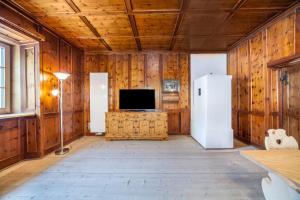 拉塞斯Unterlanpacher Historic Refugium的客厅设有木墙、电视和冰箱